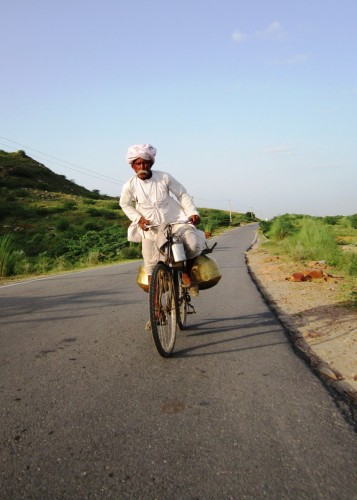 Pushkar milkman rises to the challenge of a small hill on the road in Rajasthan.