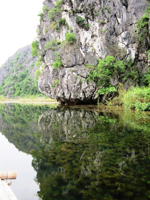 Floating along the mirrored water in our bamboo boat.
