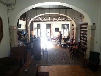 View from inside O Purista looking from the pool room to the barbershop and into the street on a sunny day